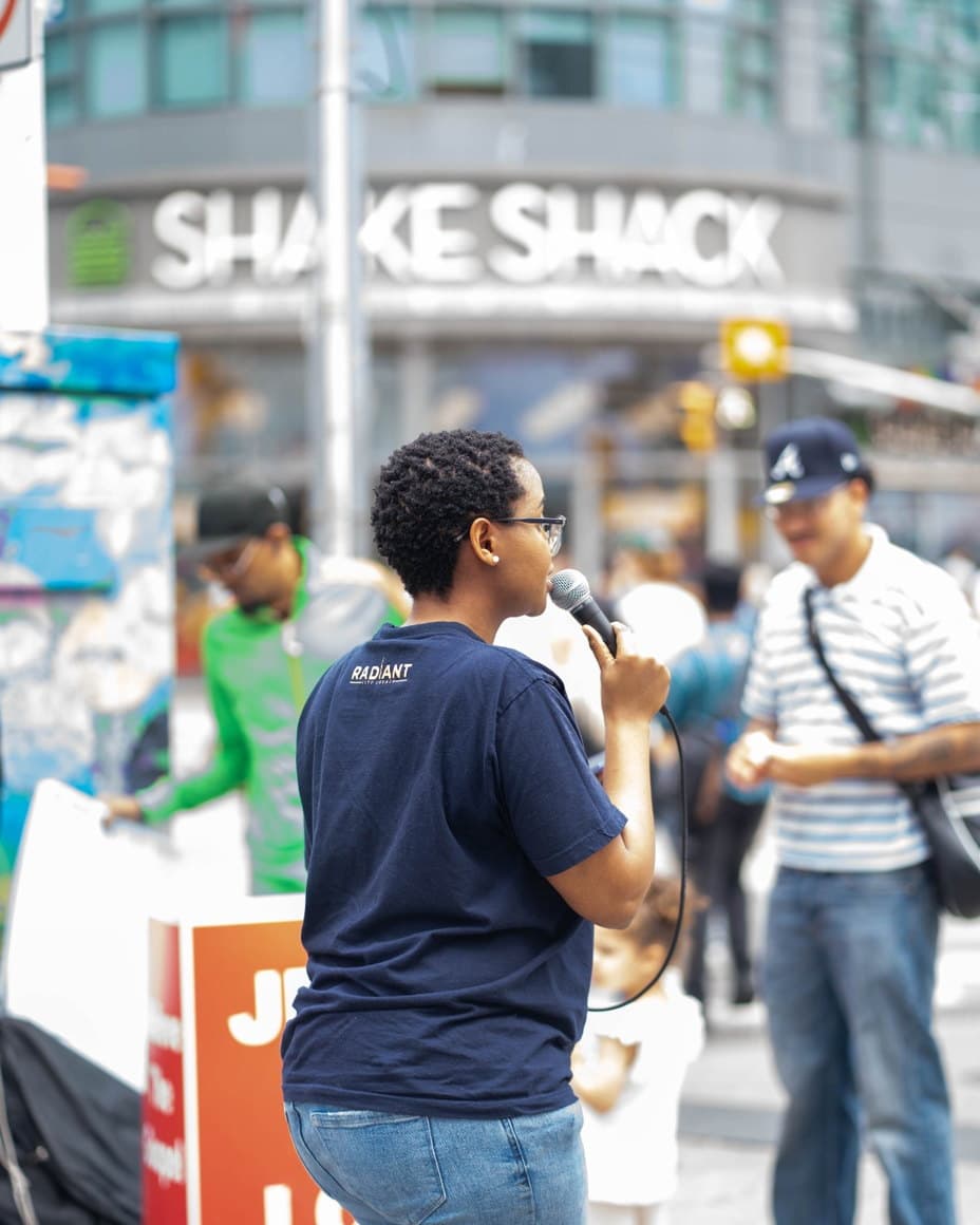 Lerato speaking to passers-by on a busy sidewalk