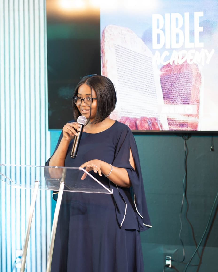 Lerato speaking at a lectern at a Bible academy